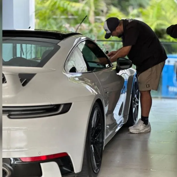 Thiago, o especialista da Restaura, aplicando PPF em um Porsche